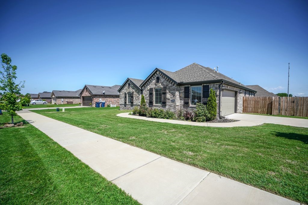 All the convenience, none of the compromise—just minutes from Walmart HQ in a location that puts everything within reach. This 3-bedroom, 2-bath home features a wide-open kitchen with granite counters, stainless steel appliances, and a generous walk-in pantry. The island connects seamlessly to the living area, breakfast nook, and a handy built-in computer station. The primary suite is set apart with a large bedroom and bath that includes a tile shower, double sinks, and a whirlpool tub. The home was built with energy efficiency in mind—Low-E windows, R13 insulation in the walls, and R38 cellulose in the attic help keep utility costs in check