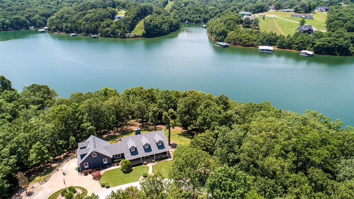Beaver Lake Lakefront (397 Ft) & lakeview!Nestled on 2.98 acres.Immense deck space to enjoy those sunny afternoons+shaded patio downstairs.Rocking Chair Front Porch.Hardwood floors,Skyrocketing ceiling,Living room with fireplace. Lots kitchen counter space@ large drawers,pantry,appliance garage,bar eating area opening into Gathering room w/high beamed ceiling @tile floor.Walls of windows allowing outside light stream in.Pan ceiling master bedroom w’glass doors towards lakeside.Gorgeous wooded view summer peek at lake @huge lakeview winter.Large master bath whirlpool tub,walk in shower.Second master downstairs similar bathroom. Nice yard areas.Beautifully landscaped.Poured concrete foundation.Seller spared no expense making sure water drained away from home.Separate guest Apartment located over garage.Located on a paved road less than 15 minutes to Rogers.Custom built one owner.Oak cabinets and fixtures throughout.696 Sq ft garage.Roof,main hvac 2021,upstairs hvac apprx 3yrs, Great time to look with leaves falling!