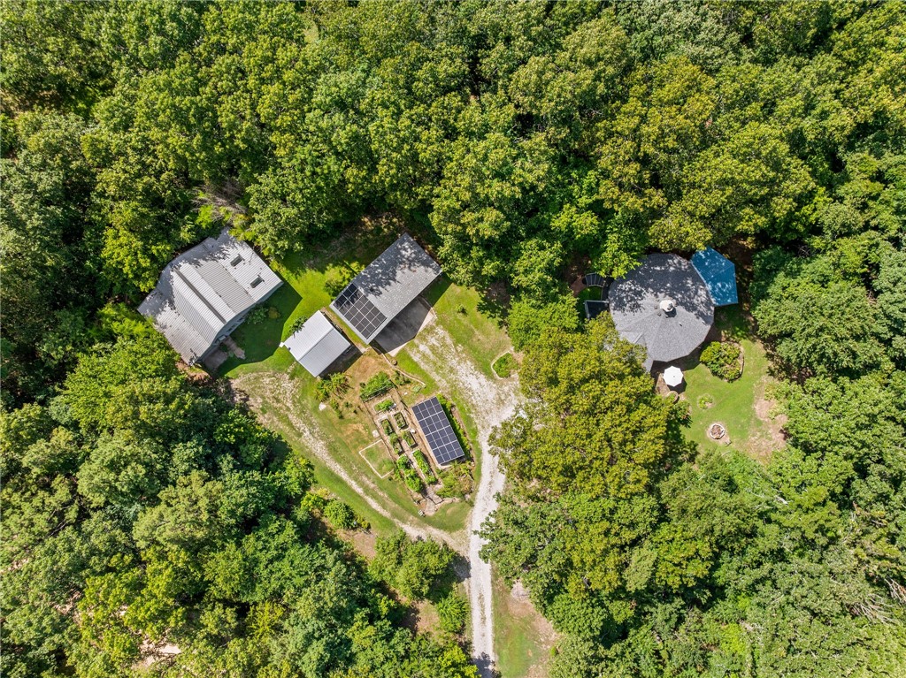 An environmentalistās dream on 50 acres with Kings River frontage and Corps-approved boat dock access. This unique, circular Cordwood home features 14" cordwood and concrete walls, a whole-house Russian fireplace, solarium with grow lights, and covered porches including a screened-in back porch. All-new appliances, clawfoot tub, Rheem HVAC, slide-out kitchen drawers, whole house sound system, Culligan water softener, and hidden access panels. Off-grid ready with solar farm, 1,000-gal propane tank, and whole-home/shop generator. The 1,600 sq ft woodworking shop has a central dust collection system. Directly across the road, a private lookout offers breathtaking panoramic viewsāa perfect spot for watching sunrises, sunsets, or just soaking in the peacefulness. Landscaped with native Arkansas plants for continuous seasonal blooms. A true wildlife sanctuaryādeer, foxes, turkey, beavers, and more.