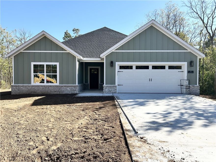 New construction on a flat wooded lot located near I-49, Lake Loch Lomond boat launch, and Highlands Golf Course! Step inside to discover an inviting open concept design featuring 10’ ceilings and beautiful floors that enhance the spacious feel of the home. The stylish kitchen is equipped with a gas range, premium black stainless-steel appliances, 3 cm quartz countertops, custom cabinets, and a walk-in pantry. Entertain or unwind in the living area, complete with a stunning fireplace, or step out onto the covered patio to enjoy the peaceful surroundings. The primary suite features a massive walk-in tile shower and closet. 2 bedrooms + office. High-end finishes throughout. Buyer can receive $3,500 in closing costs when using the builder's preferred lender! (Some images are a sample photo / same floor plan / finishes may vary)