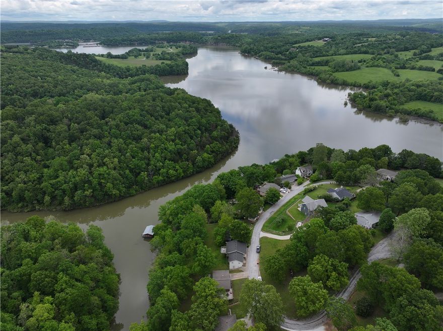 This charming lakefront 3-bedroom, 2-bathroom home with 1 slip in the co owned boat dock on Beaver Lake. You also have direct access to your boat dock. The recently renovated co-owned boat dock is up to code with the Corps of Engineers. Sit outside and enjoy the scenic lake views on your large back deck - great for sipping your coffee in the morning or entertaining friends in the evening. If you need more space, finish out the basement for more square footage. Great location in the heart of Northwest Arkansas; only 5 miles from Hickory Creek Marina boat launch, 19 miles from the University of Arkansas and 21 miles from downtown Bentonville. Currently operating as a successful Airbnb, this property is a great investment opportunity. The quiet and safe neighborhood of Shady Cove is a wonderful place for a family or secondary home to live the lake life. This move-in ready home is just steps from the shoreline of Beaver Lake and minutes from city amenities offering both tranquility and convenience.