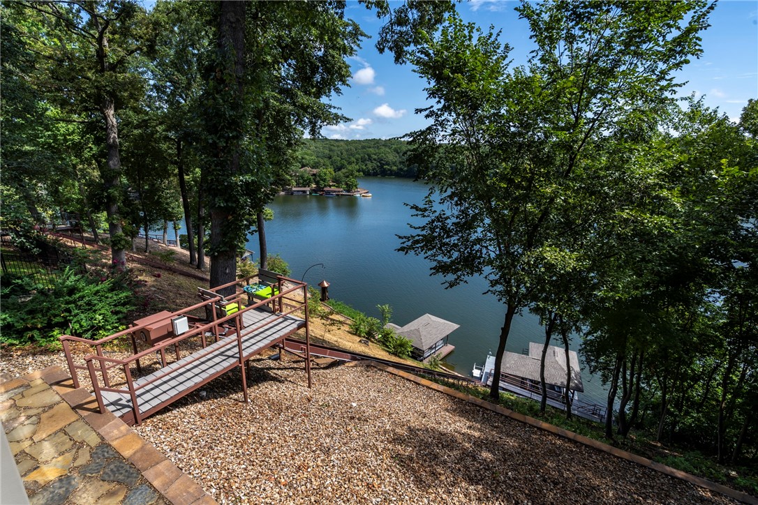 Ready for lake life? Just load everything you will need on the tram, climb in and off you go! This 2 level 3 BR 2 1/2 BA home offers 2 living areas, 2 kitchens, office, 2 sun rooms, a spare room and huge storage room. 6 in. walls &propane tank is owned and buried. The main floor trim, cabinets and rooms are freshly painted with new carpet & tile. New appliances 2022, new HVAC in 2019, reverse osmosis filtered water, new propane stove top, electric oven, and double door dishwasher. New LED lighting throughout. Upper and lower level lake views are amazing. 2 outdoor patios, the upper deck was just extended w/ new composite decking, lower walkout deck has new rockwork. Tram installed in 2023 w/ extended walkway to new dock & boathouse & new sea wall w/extended ladder access to deep, wake-free cove & a kayak launcher. Sellers purchased addl land to extend lake area. This home is located on the widest cove on Loch Lomond. Just 2 miles from Hwy 49, near Tunnel Vision and Tweety Bird trails & Branchwood ammenities.