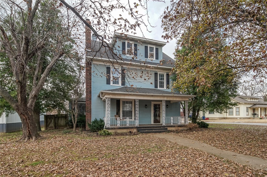 Charming historic home in Siloam Springs. So much room with over 3400 SF. Large bonus room upstairs. Enjoy evenings on the front porch. Beautifully updated kitchen. Grand entrance with lighted banisters. Two fireplaces, one wood-burning and one wood stove.Stained glass window. Newer roof and water heater. New tile, carpet, appliances and granite. New hardwood floors in formal living room, den and landing. Garage includes half bath, workbenches, furnace and attic storage.