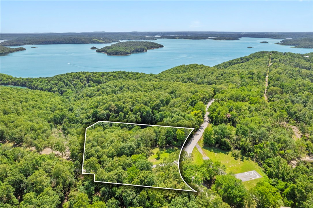Lake view lot with community boat slip in a rare, gated community on a paved road with stunning views. Perfect for building a full-time dream home or vacation lake house getaway. Lot 9 sits at the highest point in this small, curated neighborhood of nine total lots with two existing homes. A lighted, landscaped cul-de-sac at the interior of this secluded community as well as a gated entryway (nearing completion) provide an elevated experience as well as privacy and security. Wooded lots of +/- three acres allow owners to situate their future home in the ideal spot to capture the best views while keeping the right number of trees to preserve the gorgeous natural setting. Access just across the road and down the hill (4WD needed) to the community dock with community swim platform and included boat slip with locker - be on the water in some of the most idyllic parts of Beaver Lake in minutes.