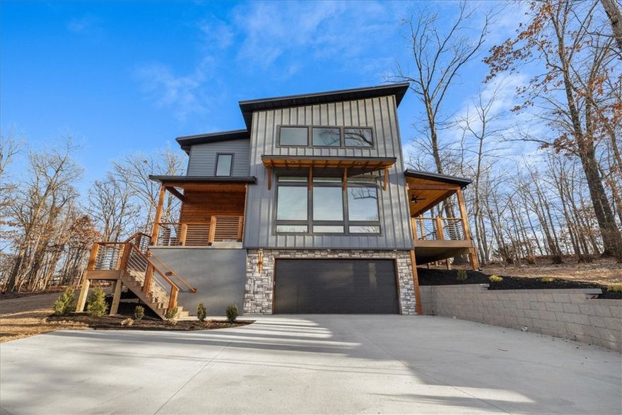 Completed and move-in ready, this striking contemporary home offers 3 beds, 2.5 baths, and 641 sq ft of bonus space across three levels. Designed with intentionality and high-end finishes, the home features 23 foot ceilings, expansive Marvin windows, and a sleek metal roof.

With a tandem four-car garage, one of the few in Bella Vista, there is plenty of room for vehicles, tools, or hobbies. The flexible downstairs area can serve as a home theater or gym. Enjoy 700 sq ft of covered decks and porches perfect for hosting or relaxing, plus a large driveway with turnaround for guest parking.

Smart Home upgrades include an EV charging outlet, 4th Gen Nest thermostat, and WiFi-enabled garage opener with security camera. Located in the Gravette School District, just minutes from Branchwood Rec Center, Highlands Golf, and Lake Lomond, with quick I-49 access.

Seller is related to the Realtor.