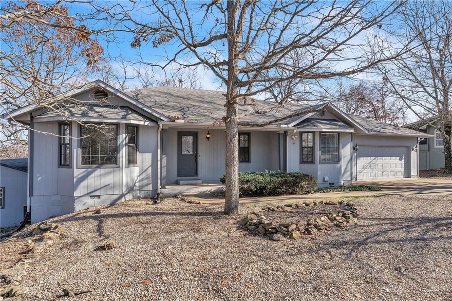 Beautiful lake area home at the end of a quiet cul-de-sac with stunning views. This home has ample room for everyone and includes 4 bedrooms, 2.5 baths, lower level bonus rooms, craft/art room, eat in kitchen,  formal dining room and tons of storage space. While it is private and feels secluded it is near the Holiday Island shopping center with all your everyday needs at your fingertips. Roof was replaced in '23, HVAC system, water heater and glass cooktop are all approximately 7 years old. Pellet stove in living room is flanked in stacked stone with glass doors on either side leading you onto the partially covered deck with long range views that will take your breath away. The lower level has a covered concrete patio that would be the perfect private spot for your hot tub. There is a second living room, full bath and several bedrooms downstairs so there is room for everyone to have a getaway space to call their own. Home office, art space, exercise room or home theater. You name it, this house has the space for it