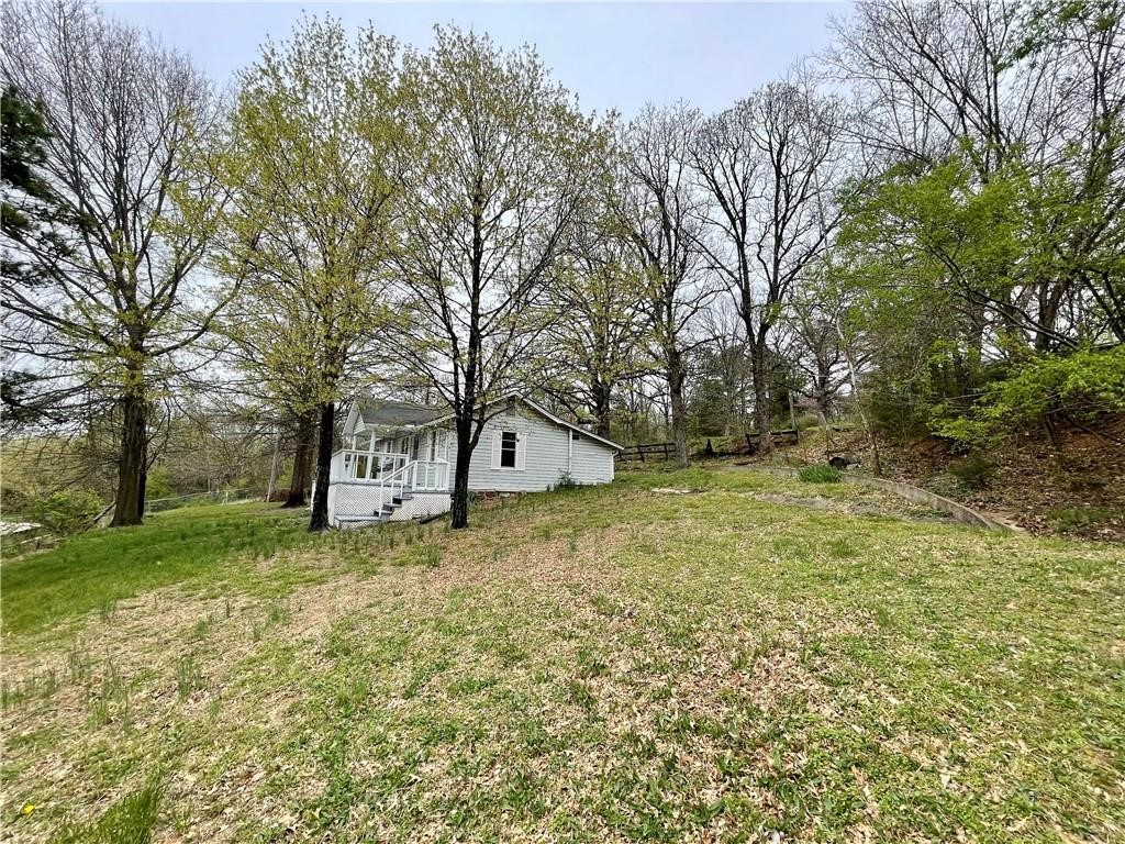 All electric. In a great location at the top of the hill is this neat, little bungalow offering a comfy base to return to at the end of a busy day. Featuring a 1bed/1bath, with an extra room for a twin bed or game room or craft room. The home features new carpet, full length front porch partially covered to sit out on your swing & enjoy the Ozark Mountain weather year round. The lot features space for a garden area or an outbuilding for extra storage. And if you need more space than that, there are storage buildings below the house for rent. The property would make a great investment property for Vrbo, or Airbnb. Fantastic for Arkansas Razorback games or floating the Buffalo River & weekend getaways or just traveling through the Ozarks.