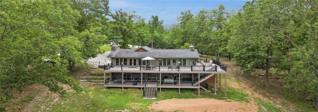Lakeview home with boat slip and dedicated workshop! Walk through your front entry and enjoy panoramic, breathtaking views of the lake or step outside on to the 2000 sq ft composite deck, spanning the length of the home. Home has experienced a well-executed, tasteful remodel from top to bottom. Main level boasts herringbone porcelain floor, custom kitchen cabinetry, beautiful granite countertops and walk-in pantry. Perfect for relaxing or entertaining loved ones. Custom staircase down to the lower level showcases the bedrooms, each with a lake view and walkout to the covered deck. Fully renovated guest bathroom and washroom are down the hall. Coveted primary suite has an exquisite bathroom with sit down vanity and roomy walk-in shower. Spacious closet off of bath along with primary office complete the lower level. Dedicated easement down to the boat dock includes one 10x20 slip. Above the home sits the 60x40 insulated, red iron shop. New roof and Pella windows installed Sept 2024!