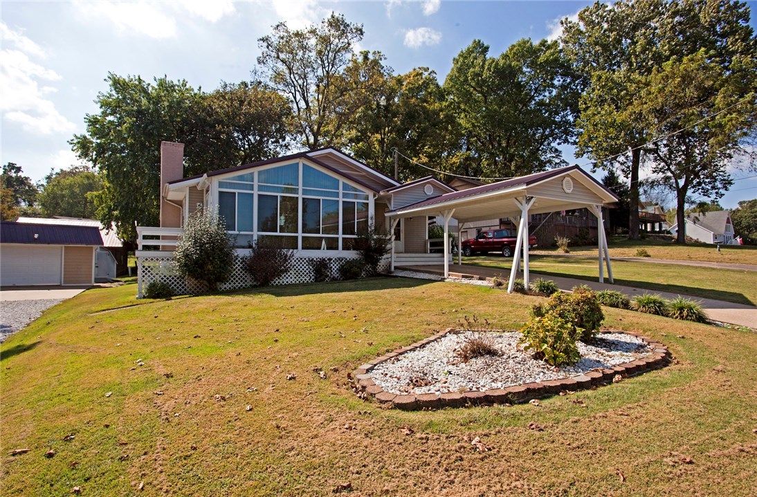 Wake up to Beaver Lake every morning. Adorable home with partial lake view from 3 sides of the home. Home features great kitchen with lots of cabinet space and storage, large sunroom with lake views, wood flooring, and a family room. Exterior features include outdoor covered pavilion with bonfire pit with paved seating, covered carport, RV parking, 2 level storage/workshop with electric, 2 community boat launches, with several public boat launches and marinas within 3-4 miles.
