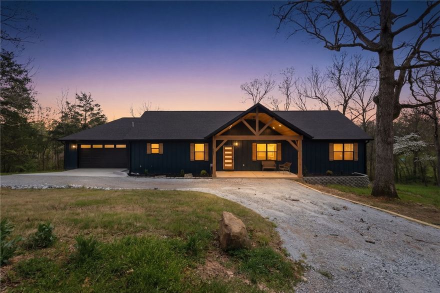 Goshen — New Construction on 1.39 Acres. No Covenants. Small town feel, Vandergriff schools, 15 min to downtown Fayetteville. This is the lot that's hard to find in NWA anymore — over an acre, no HOA, no covenants. Do what you want with it. Garden, shop, chicken coop. All of it. Inside: vaulted ceilings, LVP throughout, gas fireplace with wood mantle, and windows that actually earn their keep. Kitchen has a large island, granite tops, custom hood vent, pantry, and real counter space. Primary suite overlooks wooded views with a barn door entry, dual vanities, walk-in shower with dual fixtures, and a large WIC. Two guest rooms share a Jack and Jill bath. Office, laundry/mudroom with serious storage, and a big deck out back. New construction. Privacy. Room to breathe.