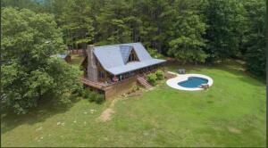 Welcome to Baldwin Creek Camp, spectacular getaway or place to call home. Primary residence, bunk house, & secondary home, all located in the Ozark Mountains on 240 pristine acres with views for miles. Joins large National Forest for 1 1/4 miles, 2 stocked ponds, w/year-around Baldwin Creek running through property. Approx 40open/200wooded rolling acres makes for a hunter's paradise or just plenty of room to explore the outdoors. Fabulous 1600sqft m/l 1br/1ba+loft main cabin with open gathering area, cozy wood burning fireplace, both covered & enclosed porches overlooking scenic grounds. Outside enjoy the heated pool, firepit, handy outdoor shower. 55x30 shop building w/unique bunkhouse/hang out and bath. additional 20x30 enclosed garage, 2drilled well, ozarks go internet.