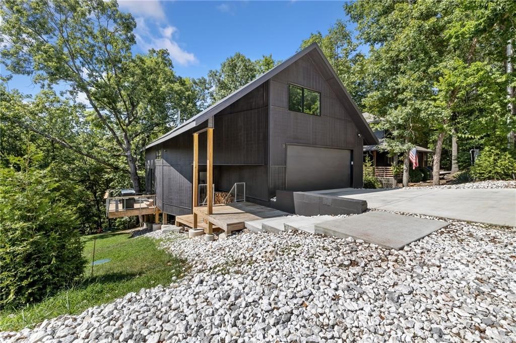 This stunning 2,557 sq/ft home offers luxurious living only 10 minutes from Bentonville Square. Designed by renowned architect Matthew Hufft, creator of notable projects like The Porch House (featured in Dwell Magazine) and hospitality venues such as Blake Street House and the 21C Hotel in St. Louis. Hufft's design aesthetic is also showcased in local establishments like The Meteor Cafe and the outdoor structures at Hobbs State Park. The home seamlessly blends comfort & elegance. Featuring 4 bedrooms, 2.5 baths & a spacious bonus room. It boasts custom cabinetry, Lutron lighting system, large custom windows, hardwood floors, & unique architectural screens. Enjoy outdoor living with 620 sq/ft of deck space and a 550 sq/ft garage with E-Charger. Surrounded by POA property gives you a secluded, treehouse feel, & it's conveniently located across from the proposed Bella Vista Bike Park & steps from Little Sugar Trail System. Perfect for those seeking a serene, upscale lifestyle close to city amenities. Sold before Print