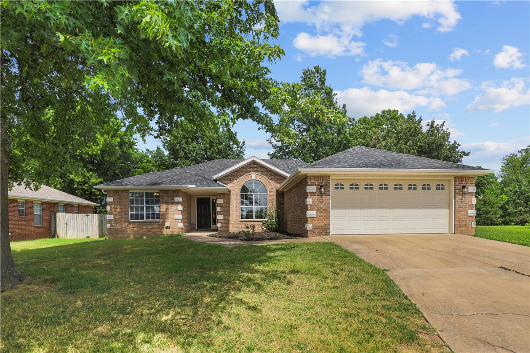 Welcome to this beautifully updated 3-bedroom, 2-bathroom home featuring a blend of brick and vinyl siding with mature oak trees. Recent renovations include a complete lighting and plumbing package, stunning 2cm quartz countertops with subway tile backsplash, new stainless appliances including electric oven and dishwasher, and stylish accent walls in the living room and primary bath. The home offers ceramic tile, vinyl plank, and carpet flooring throughout, plus double-pane vinyl windows and a newer roof. The spacious primary bathroom boasts a walk-in shower, dual vanity sinks, and generous closet space. Additional highlights include ceiling fans in all bedrooms, a gas fireplace, pantry, laundry room storage, and a 2-car garage with insulated door. The property includes a convenient outbuilding and sits in a prime location near downtown Bentonville and Walmart Home Office, with easy access to trails and local amenities.