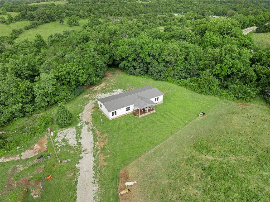 Enjoy the space and freedom of country living in this 4-bedroom, 2.5-bath home with a spacious open layout. The kitchen features ample cabinet space and a walk-in pantry. A split-bedroom design offers privacy, and the large primary suite includes a garden tub and generous bath area. The property offers a mix of open pasture and wooded areas, plus a pondāideal for livestock, recreation, or simply enjoying the outdoors.