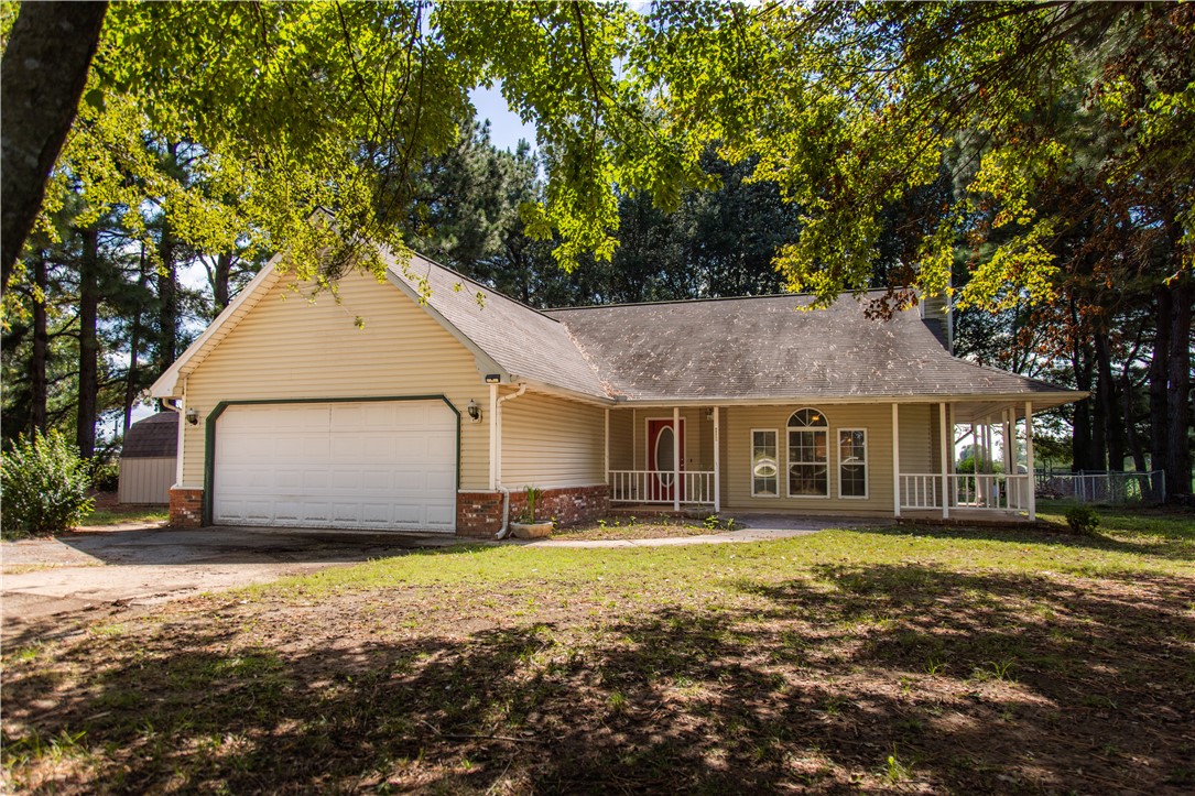 Charming 3-Bedroom Home on 6 Acres with Highway Frontage! Nestled among beautiful pine trees, this inviting property offers the perfect blend of privacy and convenience. Located just 4 miles west of Gentry and 1.5 miles east of the Oklahoma state line, enjoy easy access with Highway 12 frontage.
The home features 3 bedrooms, 2 bathrooms, a spacious living area, and a large kitchen with a dedicated dining space and walk-in pantry. Relax and take in the peaceful surroundings from the wraparound porch. The 6-acre property is fully fenced and ready for livestock. The fenced backyard is ideal for pets. The property includes multiple outbuildings: a storage shed, loafing shed, chicken coop, and a well-equipped shop with concrete floors, stalls, and a tack room perfect for hobby farming or equestrian use. A rare opportunity to enjoy country living with all the essentials already in place!