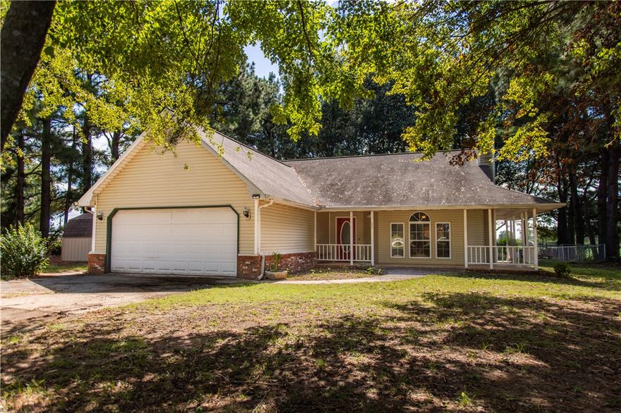 Charming 3-Bedroom Home on 6 Acres with Highway Frontage!  Nestled among beautiful pine trees, this inviting property offers the perfect blend of privacy and convenience.  Located just 4 miles west of Gentry and 1.5 miles east of the Oklahoma state line, enjoy easy access with Highway 12 frontage. 
The home features 3 bedrooms, 2 bathrooms, a spacious living area, and a large kitchen with a dedicated dining space and walk-in pantry.  Relax and take in the peaceful surroundings from the wraparound porch.  The 6-acre property is fully fenced and ready for livestock.  The fenced backyard is ideal for pets.  The property includes multiple outbuildings: a storage shed, loafing shed, chicken coop, and a well-equipped shop with concrete floors, stalls, and a tack room perfect for hobby farming or equestrian use.  A rare opportunity to enjoy country living with all the essentials already in place!