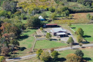 The custom block masonry drive through barn with steel trusses. 9 total horse stalls. 1 stud stall, with run partially covered, 4 inside stalls & 4 outside covered stalls . Inside stalls have built in hay racks and feeders and are plumbed for automatic waters. There is 420 sq ft of living quarters that consist of an efficiency apartment complete with kitchen, bathroom and H&A unit. There are 2 roll up doors that allow you extra convenience for storage, or tractor parking. Tack Room has concrete floor and saddle racks. There is a tool room or extra storage area, wash bay with hot water heater and dryer hookups. Hay lofts on both sides above stalls. New roof 2015. 4 dog kennels with runs partly covered that drain into a septic tank. Mineral rights do not convey.