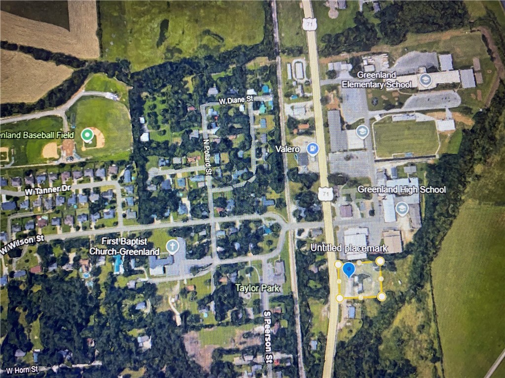 One Acre Adjoining Greenland Schools, With 271 feet of Main st. frontage. No value placed on home or out buildings, All improvements on property are sold as is.