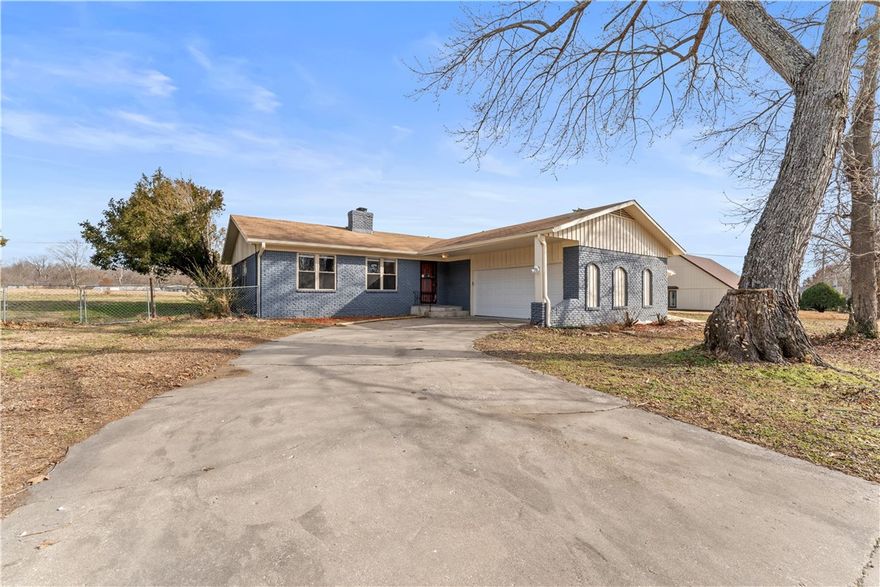 Tucked along a quiet street in Rogers, this one-level brick home, built in 2002, offers a functional layout, generous outdoor space, & the opportunity to make it truly your own. With three bedrooms, two full baths, and two separate living areas, the floor plan provides flexibility for both everyday living and entertaining.
The home features a fireplace designed for a wood-burning stove, creating a cozy focal point ready for customization. A covered patio overlooks the large, level, fenced backyard, ideal for relaxing evenings, pets, or outdoor gatherings.
Practical features include a workshop just off the garage & RV connections along the side of the home, offering added convenience for hobbyists or travelers. The setting combines privacy with accessibility, all within a peaceful neighborhood environment.