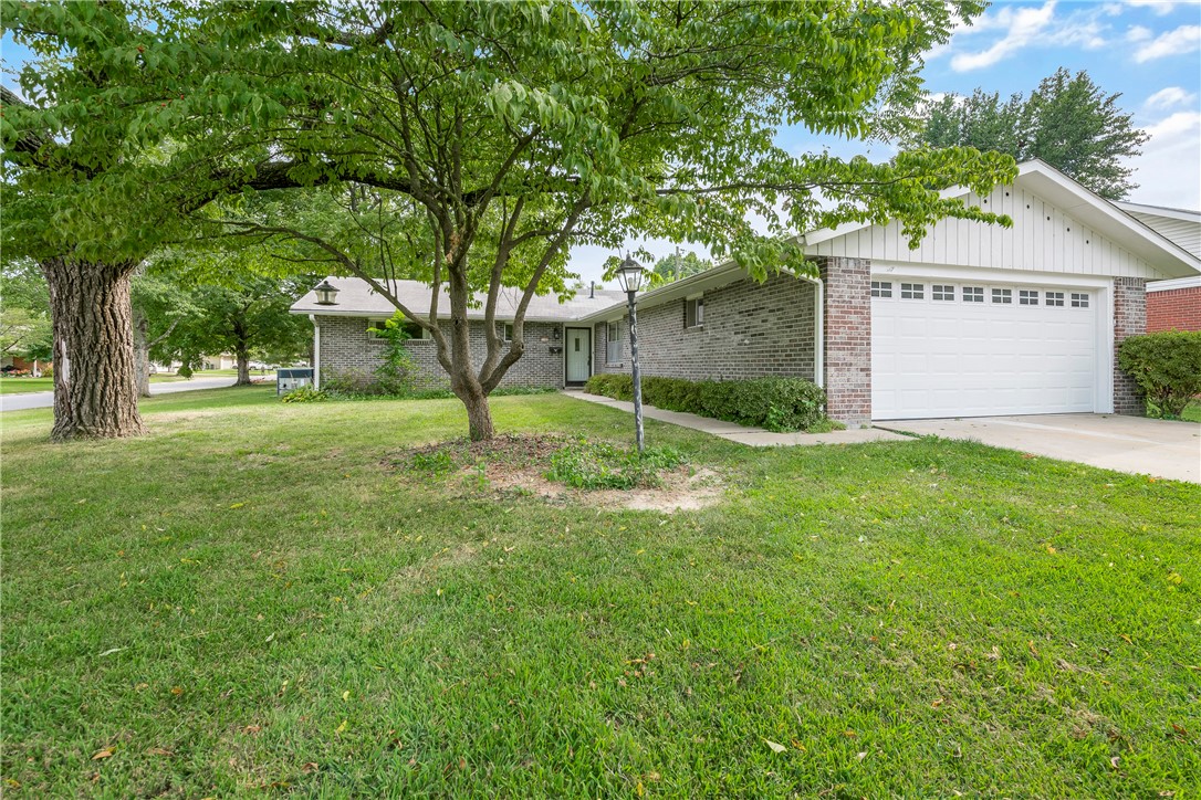 Solid brick home on corner lot in established neighborhood! Convenient location to Downtown and Central Rogers. The 1,715 sq. ft. plan features 3 bedrooms, 2 baths, cozy den with fireplace, light and bright living room, kitchen with granite countertops, oak cabinets, wall oven, cooktop, microwave, dishwasher and refrigerator all convey, with eat-in dining and sliding glass doors leading to the back patio complete with electric awning. 2020 updates include new wood look real linoleum flooring and paint. New shower and tile in primary bath completed 2023. *New HVAC system to be installed week of 11/6/23* Washer/dryer and extra refrigerator in garage also convey. Call for tour today!