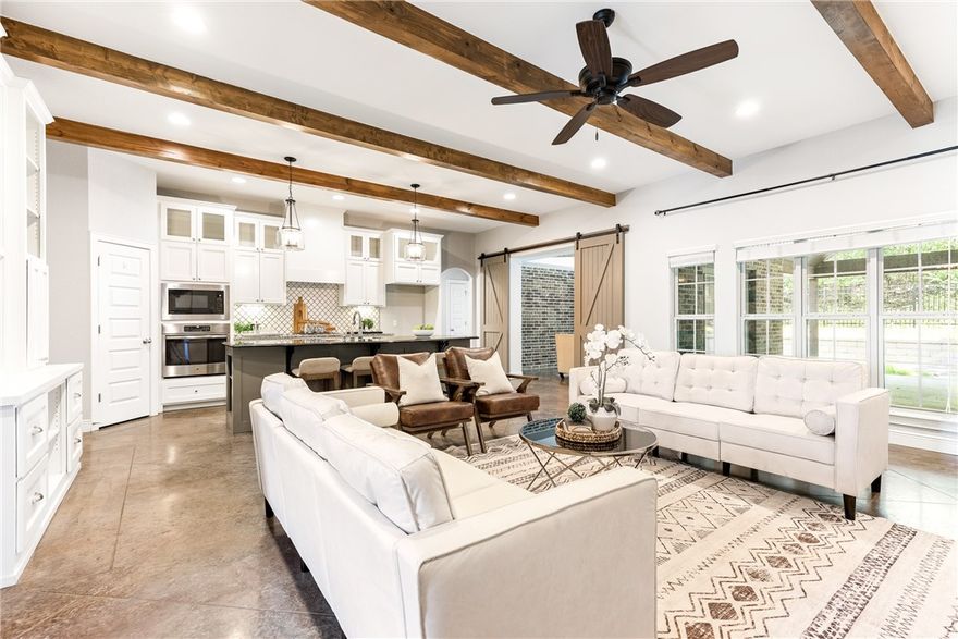 Nestled in the desirable neighborhood of Mountain Ranch, at the foot of Centennial Park, this extraordinary home is priced below its appraisal value due to being corporate owned. However, donāt let the price deceive you, this home features sophisticated designer touches, an impressive kitchen, and an inviting backyard. The home is adorned with exposed brick, shiplap siding accents, beamed ceilings, and sophisticated lighting. The main living areas feature polished concrete floors, ensuring durability and easy maintenance. The kitchen is equipped with a five-burner range, convection oven, and an oversized island. Thereās also a cool coffee bar in the kitchen. The primary suite is luxurious, featuring a spa-like bath with a vaulted ceiling framing the soaking tub, separate vanity spaces, and a walk-in shower with three shower heads and crisp white subway tile. Enjoy evening gatherings around the newly added fire pit area on the expanded back patio, perfect for entertaining.