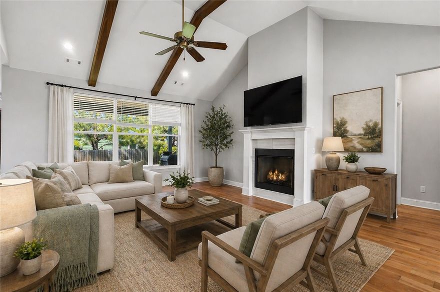 This beautifully maintained home offers charming curb appeal with a landscaped front yard and inviting covered entry. Inside, engineered white oak floors run through the primary bedroom, living room, flex space, dining area, kitchen, and guest hall. Just off the main living area, a versatile flex space is ideal for a home office, reading room, or additional sitting area. The kitchen features a large 5’ x 9.5’ island with a farmhouse sink, granite countertops, a gas stove, a coffee bar, a double-door pantry, and a custom wood vent hood with classic Shaker detailing. The living area is anchored by a gas fireplace with a mantle, and a half bath adds convenience for guests. The spacious primary suite offers a Jacuzzi tub, walk-in shower, water closet, and oversized closet with natural light. Outside, enjoy a large covered patio and beautiful, easy-to-maintain landscaping.