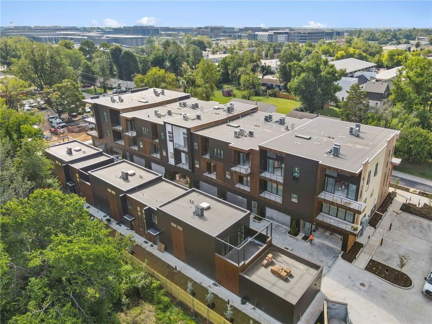 Welcome to THE HAVEN BENTONVILLE, a 29-residence luxury condo community offering flats, lofts, and penthouses. This home, The Pollock, is a sophisticated two-bedroom flat in Building Two with an open-concept design, abundant natural light, and a spacious private patio. The oversized kitchen features a waterfall-edge island, induction range, convection oven, and extensive cabinetry. The primary suite offers a walk-in closet leading to a spa-inspired bath with a tiled accent wall, designer lighting, and a shower with bench and triple shower heads. A translucent glass panel allows the bedroom to remain open for a studio feel or closed for privacy. The second bedroom, also with a privacy panel, is perfect as an office with a built-in workstation and wardrobe. Custom white oak cabinetry throughout adds warmth and style. With private access from your own garage and a location between the new Walmart campus and Bentonville Square, you’ll enjoy walkability to coffee shops, dining, and downtown.