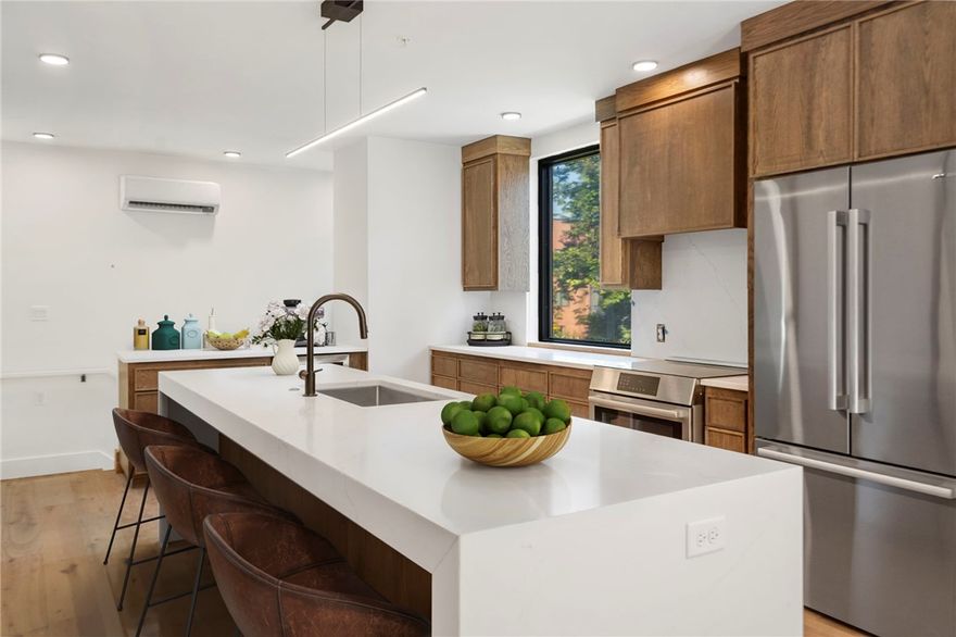 Welcome to THE HAVEN BENTONVILLE, a 29-residence luxury condo community offering flats, lofts, and penthouses. This home, The Pollock, is a sophisticated two-bedroom flat in Building Two with an open-concept design, abundant natural light, and a spacious private patio. The oversized kitchen features a waterfall-edge island, induction range, convection oven, and extensive cabinetry. The primary suite offers a walk-in closet leading to a spa-inspired bath with a tiled accent wall, designer lighting, and a shower with bench and triple shower heads. A translucent glass panel allows the bedroom to remain open for a studio feel or closed for privacy. The second bedroom, also with a privacy panel, is perfect as an office with a built-in workstation and wardrobe. Custom white oak cabinetry throughout adds warmth and style. With private access from your own garage and a location between the new Walmart campus and Bentonville Square, you’ll enjoy walkability to coffee shops, dining, and downtown.