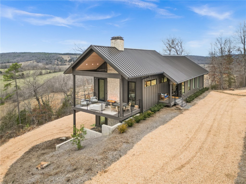 Unparalleled views of the Kings River, this custom home offers over 3,000' of river frontage complete with private trails, cave, waterfalls, & bluffs! Built with luxury in mind, this modern cabin comes FULLY FURNISHED & is equipped with quartz counters, Trex decking, expansive windows, & custom cabinets. Exploring the 48+ acres will be easy on the Honda 4x4 which conveys to buyer. Featured in January 2025's Citiscapes magazine for its architecture & design, this isn't just a home-it's a retreat. Enjoy evenings on the deck w/the fire pit overlooking the river, or weekends hunting the land, or a snow day in your own snow globe w/every room offering picturesque views. For peace of mind, the home is equipped with a whole home generator & security system.The 604 sf climate controlled garage provides ample room for toys or work space. Custom lighting is throughout the home, as well as professional landscaping including circle drive accented w/native plants. Bring your kayak to launch directly in the river from your land!