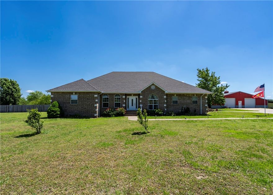 Beautiful custom brick home on 5.7 acres just minutes from town! A concrete drive leads past newly planted pecan, apple, peach & plum trees to the home & 60x60 shop. Offering 3,144 sq ft, this home features 3 bedrooms, 3.5 baths—each bedroom with a private bath—plus a large office with built-ins, a music/game room or 2nd office, & a second living area or 4th bedroom. Semi-open, split bd floor plan. Kitchen includes granite, an island workspace, gas range, double wall ovens, & huge pantry with garage access. Sewing room off the oversized utility room. Oversized bedrooms with walk-in closets. Hand-scraped hardwood & tile flooring. In-line propane water heater(6-yr). In-ground saltwater pool (4-yr liner, 2-yr cover) in privacy-fenced yard. Brick 10x16 storm shelter with electric. Shop includes 20x25 lean-to & 1,200 sq ft 1 bed/1 bath apartment-ideal for multi-generational living, in-law quarters, guests, or rental income. 17 mi to U of A in Fayetteville, 9 mi to Siloam Springs, & 15 mi to​​‌​​​​‌​‌​​​‌‌​​​‌‌‌​​‌​​‌‌​​​​ I-49.