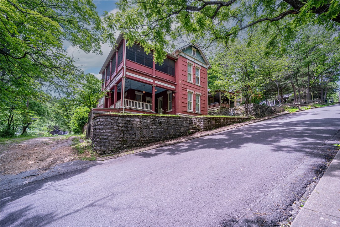 Graceful 3 bedroom 2 bath brick and stone Victorian home was built in 1897. Located just feet from historic Spring Street in downtown Eureka Springs and positioned for great views of the quaint town. Double stacked front and side porches offer shady seating areas as well as a cool screened sleeping porch. The large office/library, original fireplaces, mantels and staircases--this character-filled home is awaiting a thoughtful upgrade to more modern standards in order to be the showplace it was meant to be.