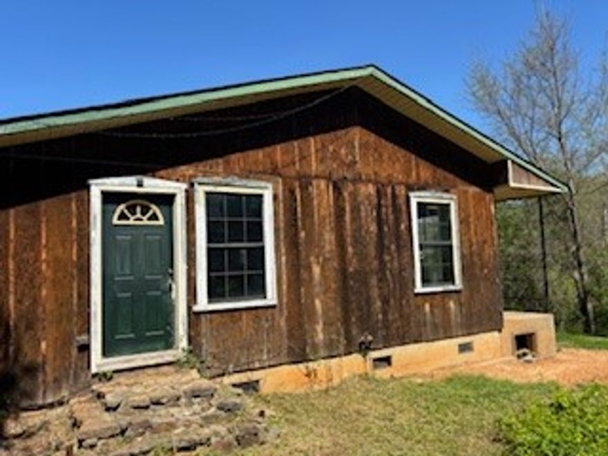 Three bedroom two bath home on 8 acres M/L. Paved road frontage. Two car attached garage. Huge covered porch.