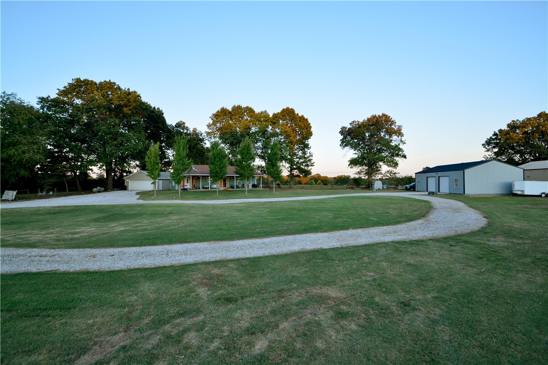 Garfield address but just on the border of Rogers. Minutes to downtown Rogers & 20 mins to downtown Bentonville! Beautifully updated home sits on 5 level acres with a separate 2 car garage along with a 30X50 shop. Shop has 12' ceilings and layout intended for future apartment. This 1408 square foot home features an open layout in the living and kitchen, 2 bedrooms with en-suite full bathrooms, a half bath, laundry room, and mud room. Complete kitchen remodel with new cabinets, granite, and appliances. Real wood floors cover the living room, kitchen, and hallway. Wood burning stove keeps the home cozy in the winter. Big wrap around porch is ideal for morning coffee or watching the sunset. Large part of the property is fenced for cows or horses. Great location being only minutes to trails, lake, or town. New well pump and wiring installed December 2019.