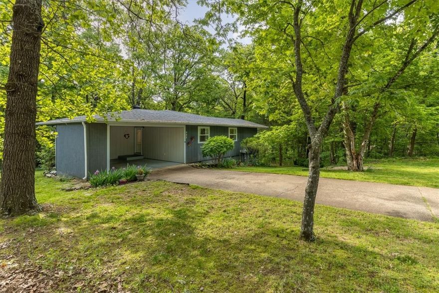 Welcome home to this charming Bella Vista retreat, perfectly positioned just around the corner from the popular Back 40 and Flo Ride trails! Beautifully remodeled in 2016 and completely move-in ready, this cozy 2-bedroom, 2-bathroom home features an inviting open-concept layout. Enjoy cooking in the spacious kitchen with granite countertops, which flows effortlessly into the bright sunroom—complete with its own separate heat and AC unit for year-round comfort. Relax in the generously sized living room, showcasing the original rock fireplace (usable with insert only), offering both character and warmth. Step outside onto your newly replaced 10x20 deck, perfect for entertaining or peaceful mornings overlooking your private backyard. The primary suite provides a serene retreat, featuring a roomy walk-in closet and ensuite bath with a walk-in shower. Additional perks include a convenient 10x12 workshop area beneath the home, complete with brand-new wooden doors, plus an 8x10 shed for extra storage.