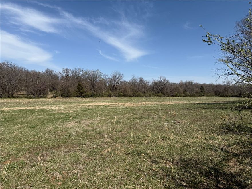Prime 20-acre corner tract located on a paved intersection, offering excellent accessibility and development potential. The property features water and sewer at site (must confirm ability to tap), enhancing its readiness for construction currently zoned R-1. A flood plain runs through the center of the tract, but buildable areas are available on both the north and south sides, outside of the flood zone and there could be potentially more if built out of the flood area if allowed by City. These elevated sections present strong opportunities for targeted development, with flexibility for specific lot placements to maximize usable land. Ideal for investors or developers seeking a well-located parcel with utilities close and solid potential for a thoughtful, phased project or estate homes with larger lots.