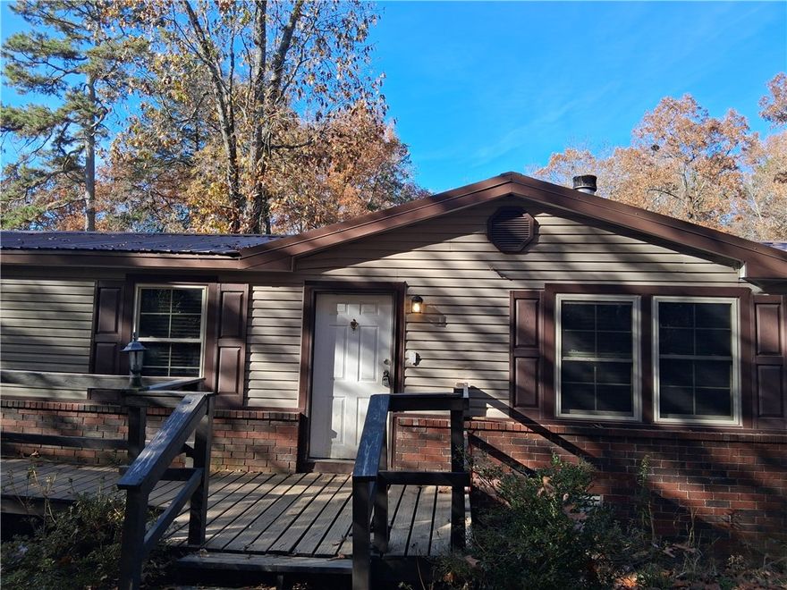 Private doublewide manufactured home with a permanent brick foundation. It has 4 bedrooms, 2 baths and above ground pool. A 520 SQ detached garage with brick and vinyl and metal roof, as well as dog fence, and a creek on the property. This property sold as is, and it is a SHORT SALE!