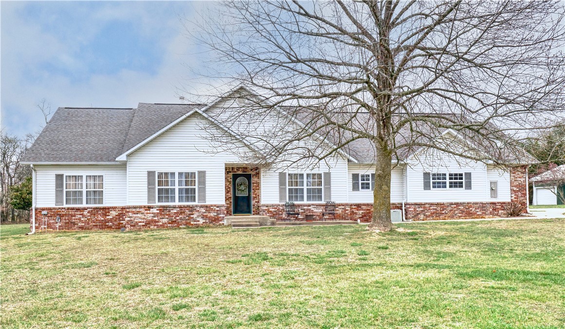 Come enjoy country living with 5 acres of flat land, home, and large 50x35 heated/cooled shop located just 20 minutes from downtown Rogers, and a short drive to Lost Bridge Marina and Beaver Lake. This home comes with 3 spacious bedrooms, an office that could be used as an additional bedroom, and 3.5 bathrooms. There is an in-law suite with a kitchenette, and its full private bathroom. The large open living room has a wood-burning fireplace. There is a spacious kitchen with plenty of counter space, an island, and a breakfast nook. The home also has a formal dining room, and formal living room space! Above the garage, you will find a finished flex room perfect for a game room or extra storage. A portion of the yard has a chain link fence perfect for your pet. Public water was run to the house in 2023. The home has all new toilets, new light fixtures, new french doors, new flooring, and new paint. The roof is two years old.