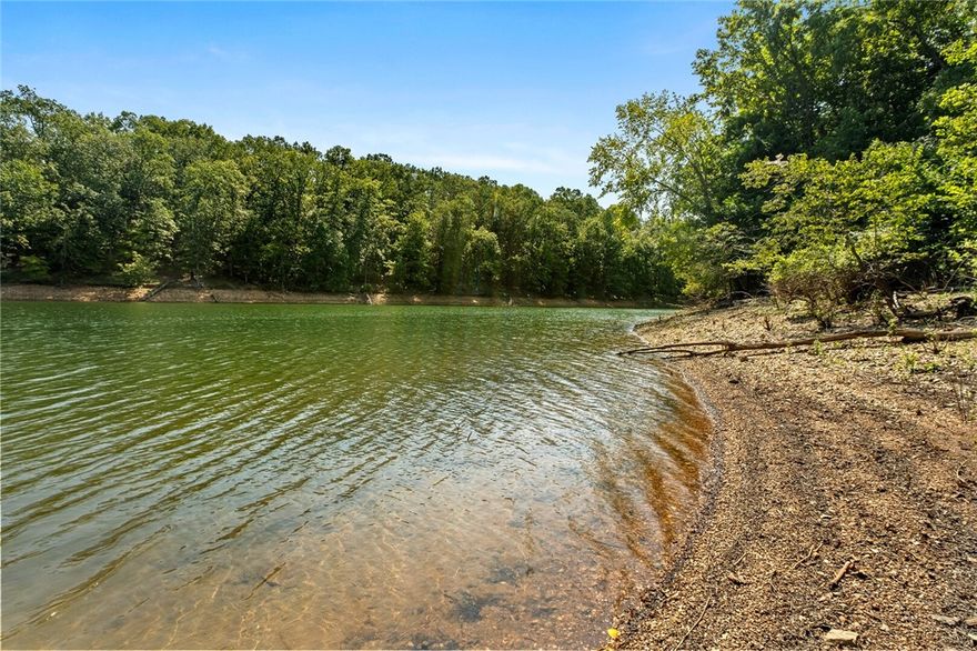 This Stunning 6BR, 3-Level LAKEFRONT Retreat blends Elegance & Comfort with Cathedral Ceilings, Double Spiral Staircases, & a Dramatic 2-Story Wall of Windows showcasing Peaceful Beaver LAKEVIEWS. Multiple Living Areas, Formal Dining, Sitting Room, Walk-Out Basement, & 3-Car Garage provide ample Space for Living & Entertaining. Outdoor Spaces feature Brick Patios, Lush Lawn, & a Lakeside Garden Terrace with Fountain & Seating – a Magical spot to unwind by the water. A flat walkway leads to your BOAT SLIP in Community Dock, w Prairie Creek Marina just around the corner. Nestled in a welcoming neighborhood yet minutes From dining, shopping, & entertainment in Rogers, this Home Perfectly blends Lake Life & City Convenience.