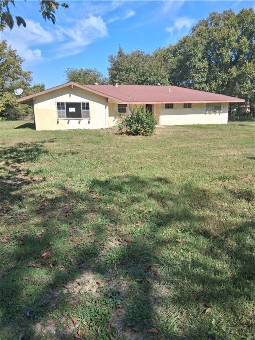 Fix-up home sold "as is".   This treed flat lot close to Centerton has house, barn and outbuilding with a pond on the backside of property.