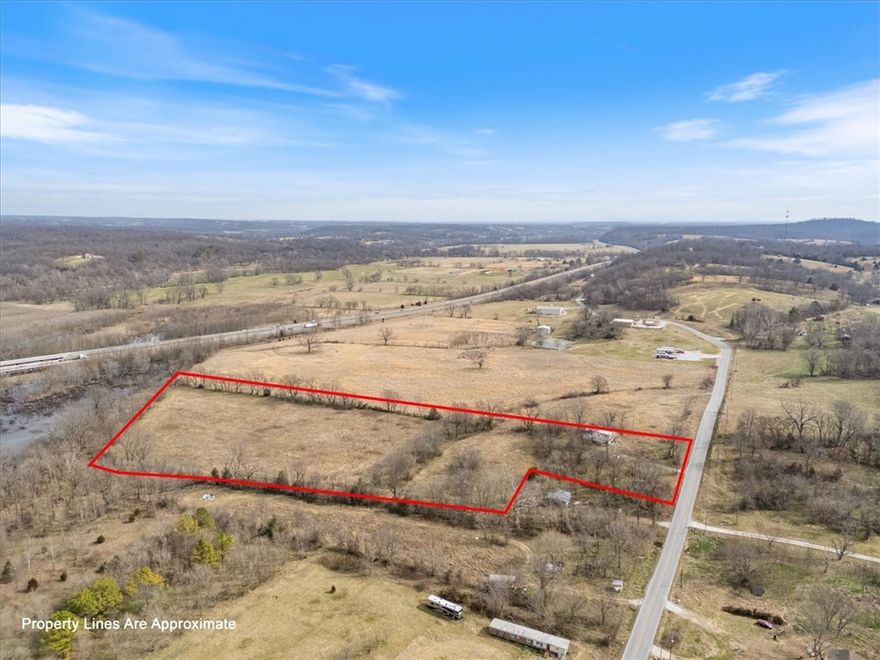 8.68 Acres ± Prime Location Near Siloam Spgs & Tontitown-offering a fantastic opportunity for a new homesite, mini-farm, or future development. Located just 6 miles from Siloam Springs & conveniently close to the Tontitown and Springdale areas, this property provides a peaceful setting with easy access to NWA amenities. A vacant home of no value is located on the property. The residence prev shared a spring; however, the seller has surveyed out approx 1 acre to retain ownership of the spring. New owner will need to install a well or independently verify the possibility of a water tap believed to be avail from Tontitown at the rear of the property. Buyer to satisfy themselves regarding all utilities based on intended use. Elect service is avail on site through Carroll Electric Coop. No natural gas is available. A portion of the back left corner of the property lies within a flood plain. Pink survey flags are visible on the property. This acreage offers location, flexibility, & opportunity—ready for your vision.