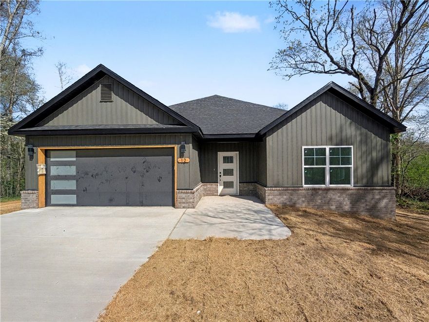 Welcome To Your Next Home At 12 Aycock Lane, Where The Yard Is Actually Usable And The Finishes Are Genuinely High-End. Tucked Away On A Quiet Cul-De-Sac, This New Construction Standout Sits On A Massive 0.45-Acre Lot Featuring The Kind Of "Bella Vista Level" Backyard That Is Nearly Impossible To Find. The Curb Appeal Is Just The Start. Step Through The Open Entry Into A Living Space Defined By Airy Vaulted Ceilings And Sharp Beam Treatments. The Back Wall Makes A Statement, Featuring A Floor-To-Ceiling Fireplace Framed By Windows That Bring The Wooded Scenery Indoors. The Kitchen Is Built For Real Life, Featuring Custom Cabinets, Quartz Countertops, A Vented Hood, Pantry, Under-Cabinet Lighting, And A Huge Island Ready For A Spread. Your Primary Suite Delivers With A Soaker Tub, Custom Tile Shower, Potty Closet, And Dual Vanities. Construction Wraps In April 2026, Meaning You Can Still Pick Some Of Your Own Colors And Finishes Today. Don't Just Dream About It — Come Buy It.