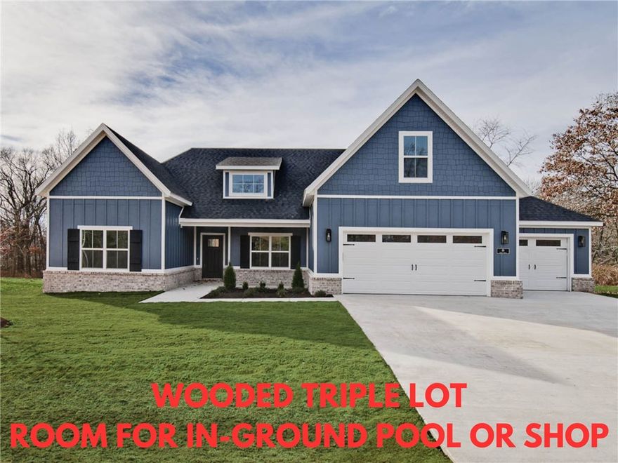 Stunning new construction home with a 3 car garage on a huge .91 acre wooded lot that backs up to farmland. Located down the street from Tunnel Vision Trail Crossing, Lake Windsor boat launch, and provides easy access to Bentonville. Plenty of room for an in-ground pool or shop! 4 bedrooms on the main level and a bonus room with full bath which could also be utilized as a 5th bedroom. The vaulted living room features beautiful beams and elegant floors, adding to the home's charm. The kitchen showcases an oversized island, custom cabinets, stainless steel appliances including a gas range, and 3 cm quartz countertops. Retreat to the primary bath, which offers a luxurious large walk-in tile shower, a free-standing tub, and generous closet space. Bentonville schools! Huge covered back patio! Front exterior color will be SW Illusive Green. Plus, take advantage of $3,500 in buyers closing costs, courtesy of the builder's preferred lender!