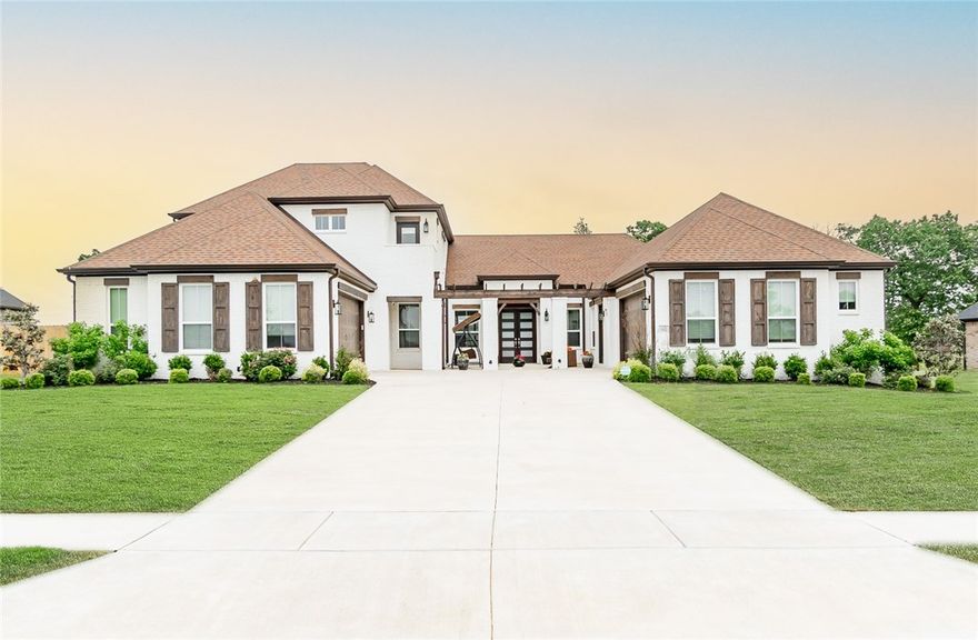 If you have been waiting to get into the Otter Creek subdivision, this is your chance!  Located just minutes from Rogers, Bentonville, Springdale, Mt. Hebron Park, Razorback Greenway, and the Promenade.  This gorgeous home starts with an open courtyard flanked by two 2-car garages. The curb appeal is stunning, with professional landscaping and a sprinkler system to keep your lawn looking healthy all summer. The luxurious split floor plan boasts 5 bedrooms as well as a home office.  The master bedroom and 2 additional en-suite bedrooms are located on the main level with 2 more bedrooms upstairs. Two living areas, a spectacular covered patio, game room, media room, and oversized kitchen with double ovens, and professional fridge provide ample opportunity for entertaining.  Gas log fireplaces in both living areas keep you warm and cozy year-round. Outdoor lovers will enjoy lounging on the covered patio that leads to a heated pool as well as the community amenities that include trails and a basketball/tennis court.