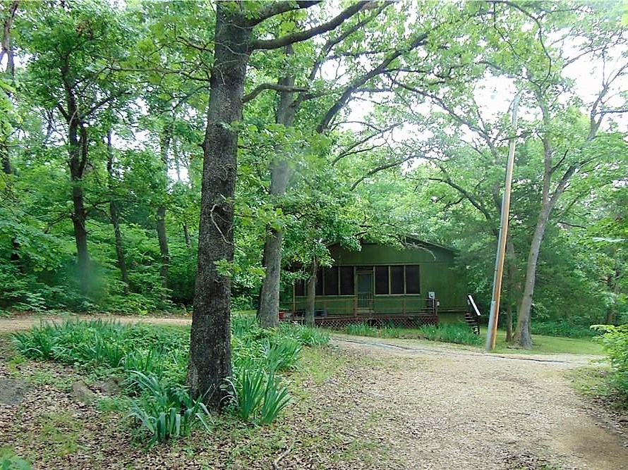 Cabin in the trees! This 2 bed, 2 bath home is surrounded by trees has wood floors, open kitchen-living area, sunroom, deck on the front of the house. This property has a Green Forest address but is located just a few miles east of Berryville.