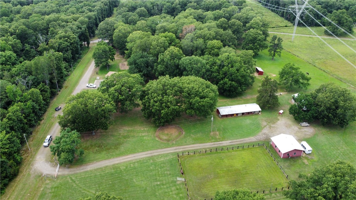 BEAUTIFUL COUNTY HOME ON 34+/- ACRES. Discover your dream property with this charming 3 BR, 3 BA home just outside Russellville City limits. Home is 1971 square feet with a cozy wood burning fireplace and split floor plan. Enjoy the property with a 36X 40 Hay barn, 70X20 Stall barn with 6 stalls and tach room, 30x30 Metal workshop with concrete floor and bathroom, a very nice size 160x100 riding arena for all your equine needs. The property has one pond and a wet weather creek on the North end of property. The Carport is set up for a full time hook up for a camper with all utilities on site. Roof is only 1 year old. This is the perfect property for Horse lovers and has been used as such for the past 40 years if your looking for peaceful rural lifetsty but only minutes from town they here it is.
