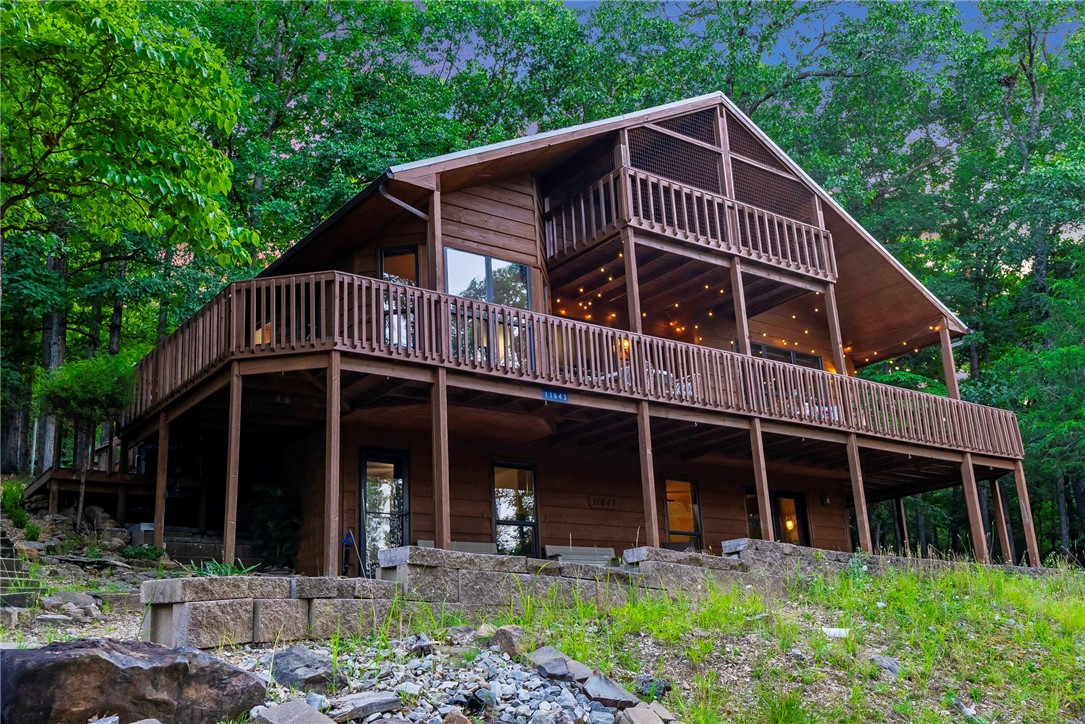 Are you looking for a weekend getaway, primary home at the lake or an investment for your growing rental business? Look no further! This is a unique opportunity to own a lake home with 3 large bedrooms, 3 full baths, 3 decks with plenty of room to entertain your guests or to escape your busy life and relax or earn rental income. The kitchen features granite countertops, stainless steel appliances and a breakfast area. A large dining area opens up to a cathedral ceiling living room featuring a cozy fireplace and large windows with seasonal lakeview. The 2nd floor features a large bedroom, full bathroom and a relaxing reading nook looking over the living room and walks out to a screened in deck. Enter the basement mudroom after enjoying the lake or hiking/biking NWA trails with room to store your gear. The basement has a full bathroom and a large bedroom with pellet stove.
The large heated and cooled garage has a half bath with ample storage space and a workshop. LBV pool, airstrip, rec room, beach & more.