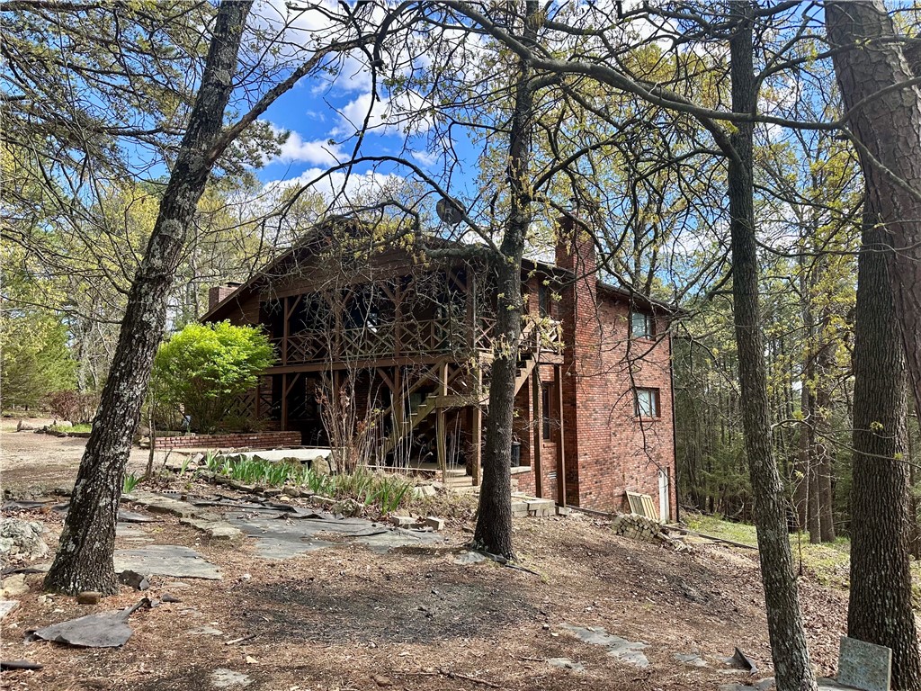 Only minutes to Beaver Dam and Lake access. Country living on 6 plus acres. Two outbuildings- the two car garage is attached by covered walkway and large workshop is a Berm building. Only a short distance on county road to State Highway 187 and RiverLake store/station on Highway 62, then aprox. 4 miles to Historic Eureka Springs. Home is older and needs new carpet and some upgrades, but otherwise a very nice and spacious country home. Four Bedrooms (two of them have full baths) and a half bath in hallway for guest, provides a nice family home or retirement home, with plenty of room for house guest. Lower level can be accessed from front of home for a wheelchair. Parents have passed and family is selling home in AS IS condition. Brick exterior means lower maintenance. 1040 sf workshop needs some repairs but has multiple possibilities. This property is not restricted to Nightly Rentals so your possiblities are endless for this property. This home offers two primary bedroom suites for couples who want their own