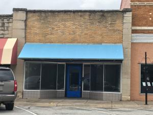 Great location on the square between the Lyric Theater and Townhouse Cafe. Main level with an upstairs, bathroom, extra storage areas and yard. Two rooms were previously a vault but do not have the vault doors now. 2nd deed includes alley as part of property. New heater 2012; New A/C 2018; new carpet in back room 2019.