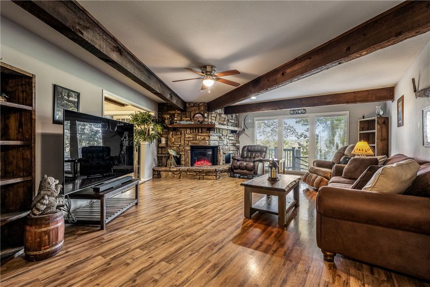 Delightful ranch-style home, where stone accents and a pergola-covered entry create an inviting first impression.. Inside, a stunning natural stone fireplace anchors the living space, complemented by rustic wood beams that add warmth & character throughout. The spacious kitchen is a chef’s dream, featuring a unique brick accent wall surrounding a 5-burner gas cooktop, w/ample
counter space & storage. Large windows bathe the home in natural light, enhancing the
open, airy feel. Currently used as a third bedroom, the cozy den includes a built-in Murphy
bed, a huge closet, & custom shelving—offering great flexibility for guests or home office
use. Step outside to enjoy views of the Kingswood golf course above the scenic "Danger
Will Robinson" trail through an expansive sliding glass door. The yard has come alive
w/mature trees, shrubs, and colorful perennials blooming in thoughtfully maintained
flower beds. Recent updates: Water Heater ('24), HVAC System ('24), Roof
('18). Home on a 2-bedroom septic system.