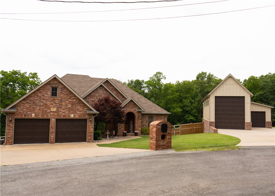 This stunning 2-story home, conveniently located minutes from HWY 71, includes a 1200sqft detached garage, perfect for your large RV with its 14' door. The main level features a split floor plan with an open living space and beautiful natural light. The upstairs kitchen includes upgraded stainless steel appliances, granite countertops, and plenty of pantry space. Just steps away from the kitchen is the stairway to an entertainer's dream come true. Designed with modern elements, you'll forget you're in the basement from the large windows to the 9' ceiling. this home is on a three-bedroom septic. The basement holds a full kitchen, built-in speakers, a projector, and a remote-controlled projector screen perfect for movie night or having family and friends over for the big game.